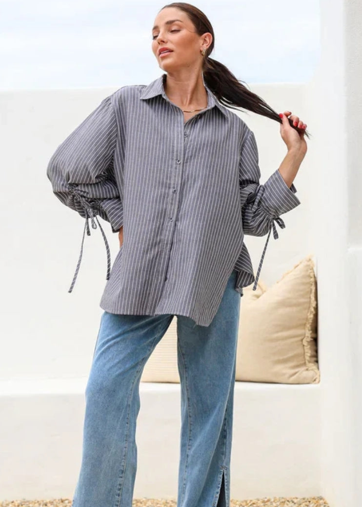 Model wearing oversized charcoal stripe shirt with tie-cuff sleeves