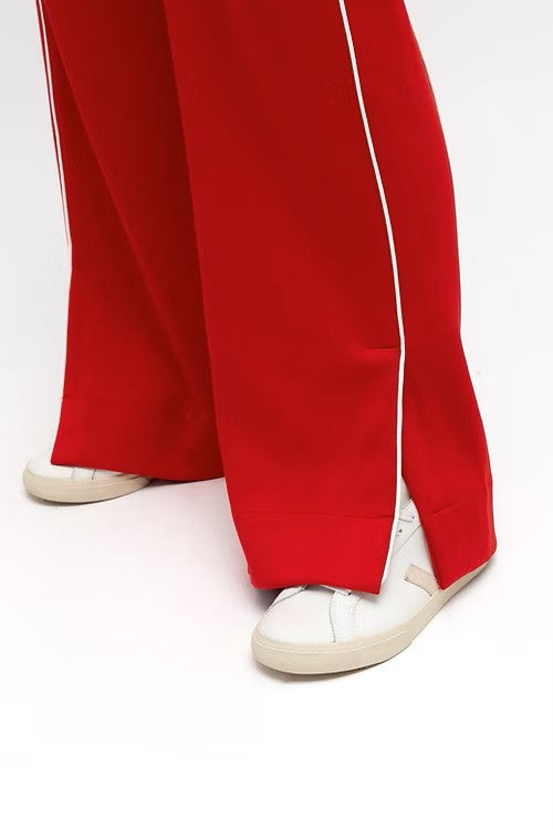 Model wearing vibrant red wide leg pants with elastic waistband, styled with a fitted white tank.