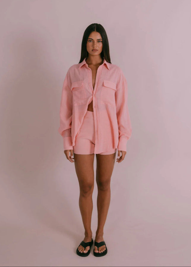 Model wearing fitted high-waisted ribbed knit shorts in pinky peach with elastic waistband from Vivian The Store
