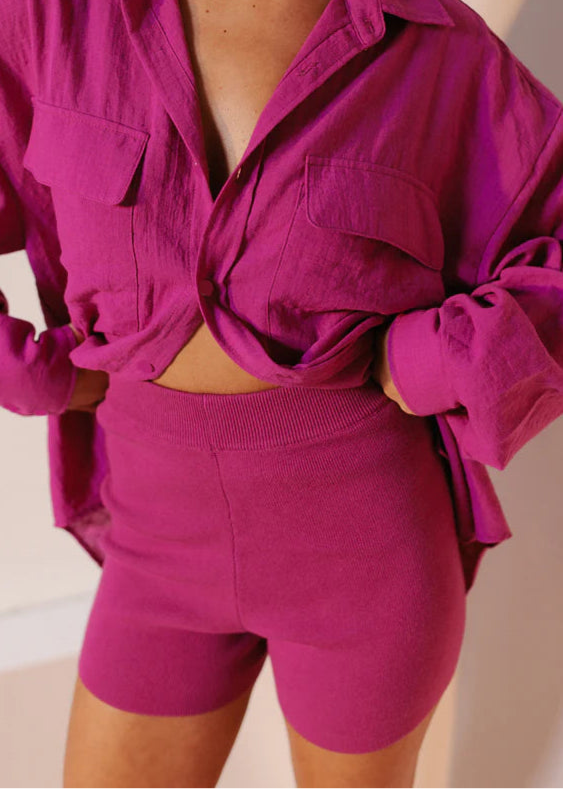 Model wearing fitted high-waisted ribbed knit shorts in vibrant magenta with elastic waistband from Vivian The Store