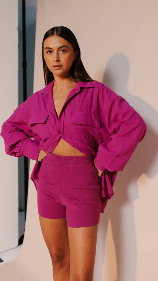 Model wearing fitted high-waisted ribbed knit shorts in vibrant magenta with elastic waistband from Vivian The Store