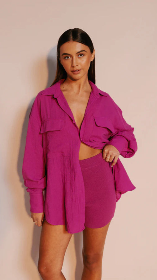 Model wearing fitted high-waisted ribbed knit shorts in vibrant magenta with elastic waistband from Vivian The Store