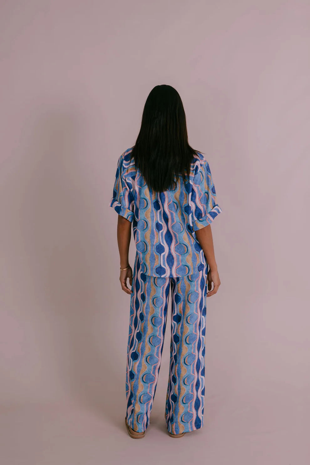 Model wearing Corfu Shirt in Greece Print Blue with boxy fit, short cuffed sleeves, button-through front and scooped hemline